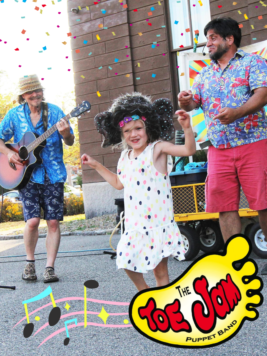 A little girl wearing a polka dot dress and an oversized furry yak hat with horns grooves with two smiling musicians/performers.