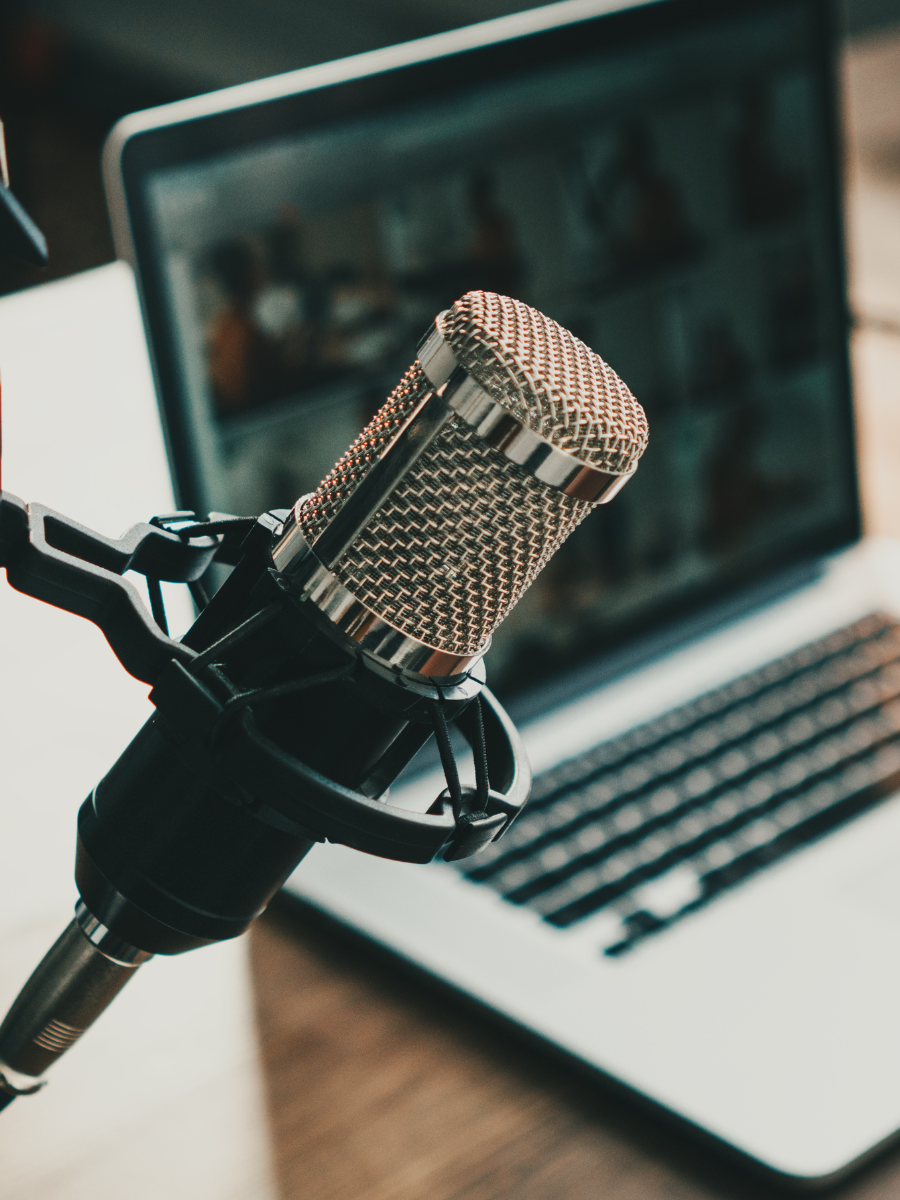 podcasting microphone and laptop sitting on desk