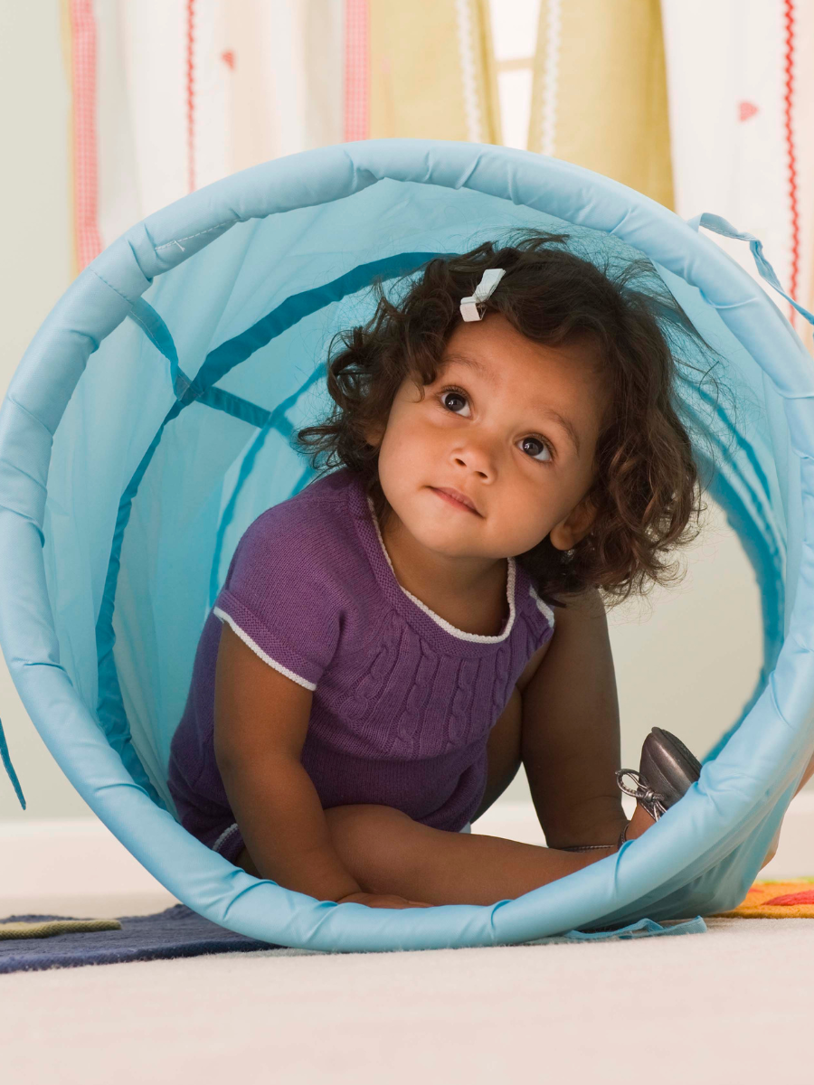 child in light blue pop-up tunnel toy