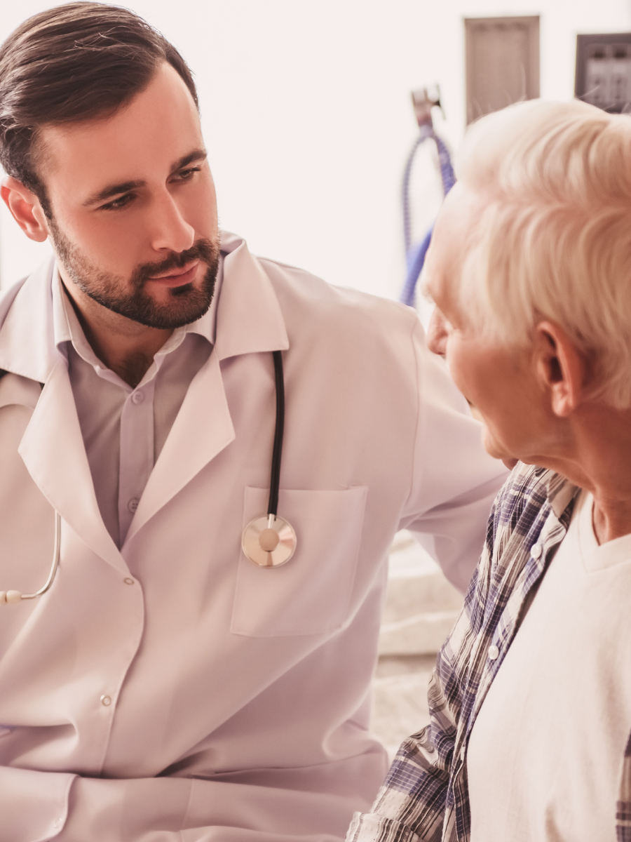doctor in white coat looking at older male patient