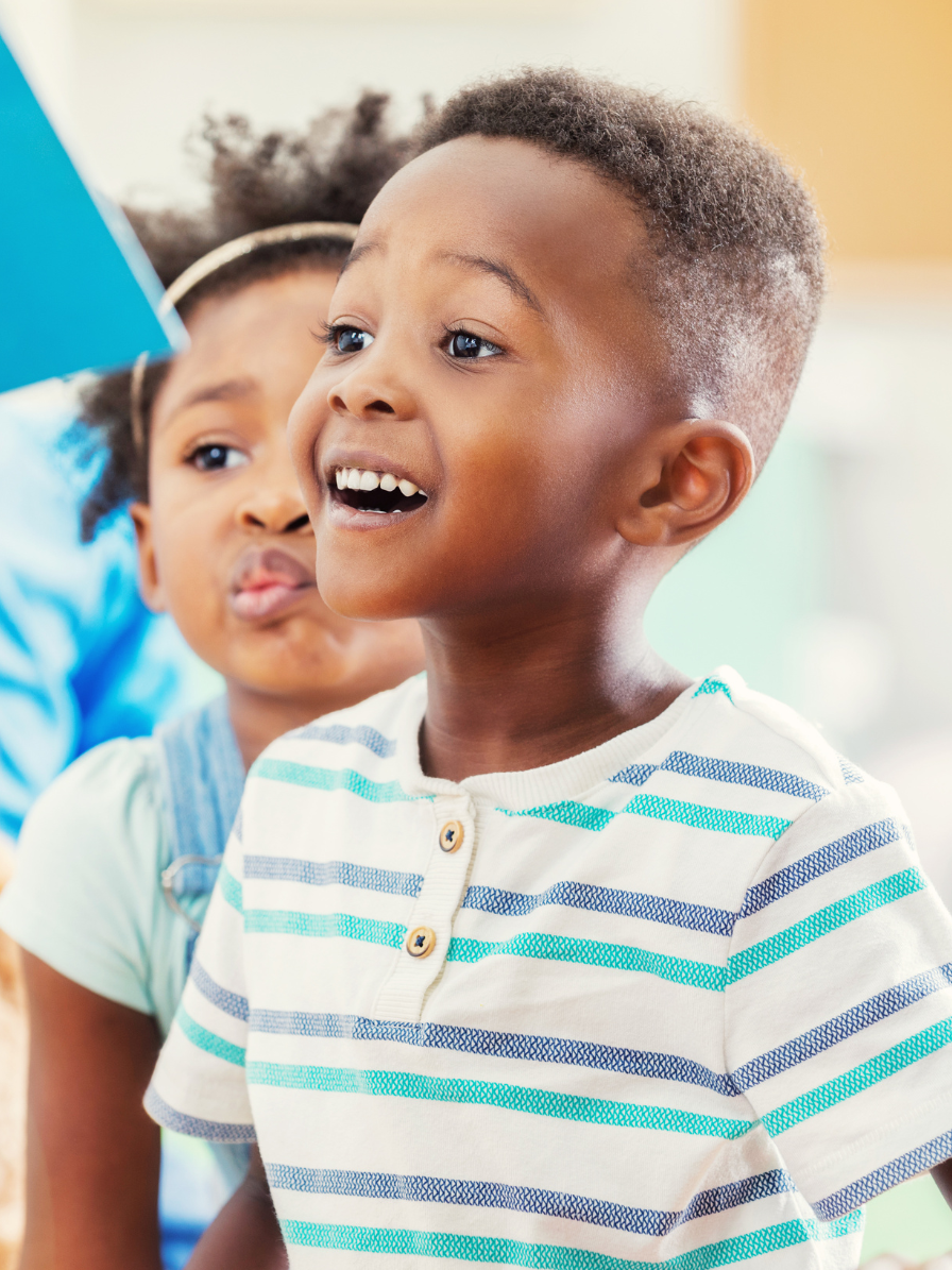 Two children, excitedly enjoying a read-aloud.