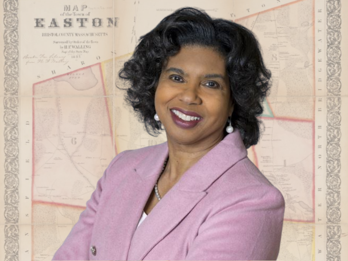 Lisa Braxton in a pink blazer in front of a vintage map of Easton