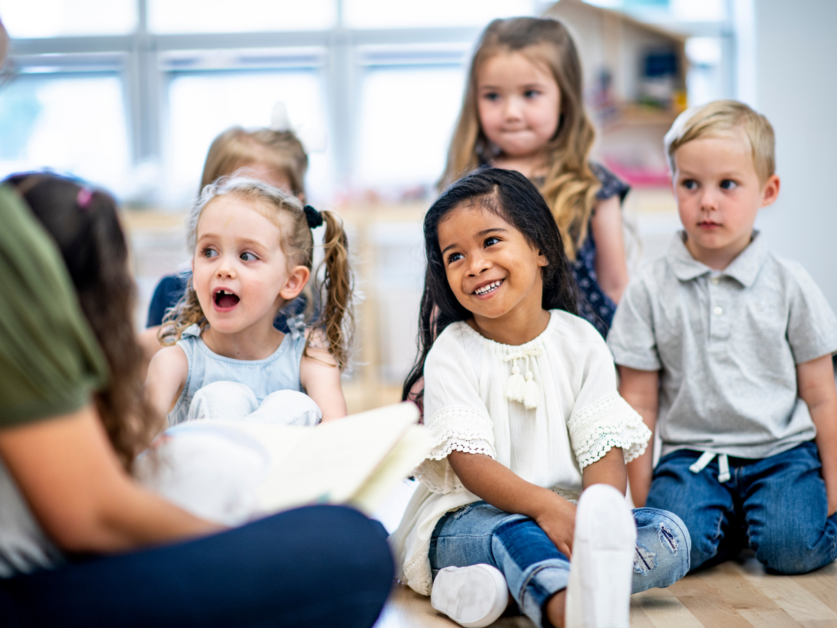 Children listening to a story while sitting on the floor.